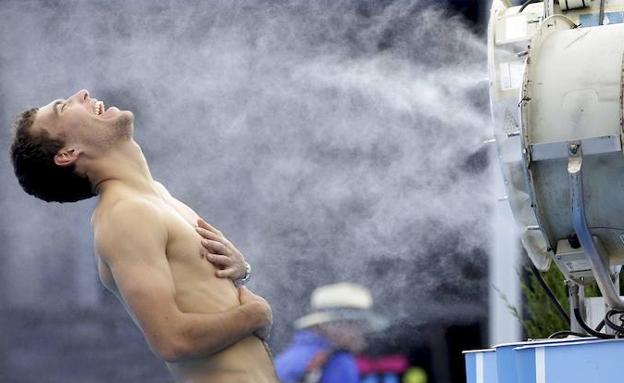 El tenista polaco Jerzy Janowicz se refresca ante un ventilador durante un partido del abierto de Australia. /Fiona Hamilton (Reuters)