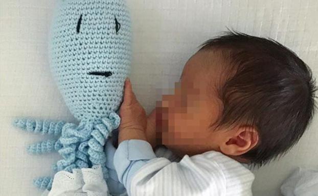 El bebé metido en la cuna.