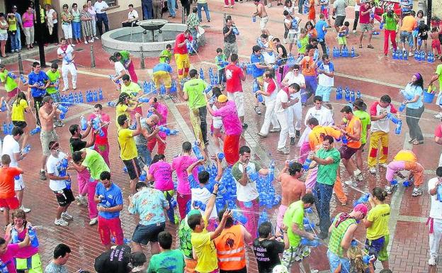 Vecinos y peñistas disfrutan de la gran sifonada en unas fiestas pasadas.