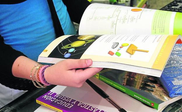 UIna mujer ojea un libro de texto.