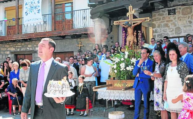 Ofrenda de los bollos maimones por dos de los mayordomos ante la imagen del Cristo.
