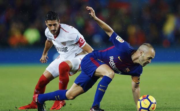 Andrés Iniesta cae en pugna con Escudero. /Efe