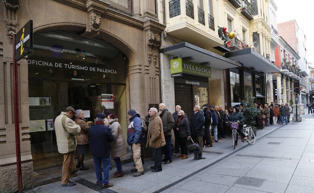 Decenas de vecinos hacen cola en la oficina de turismo para conseguir un calendario./Antonio Quintero