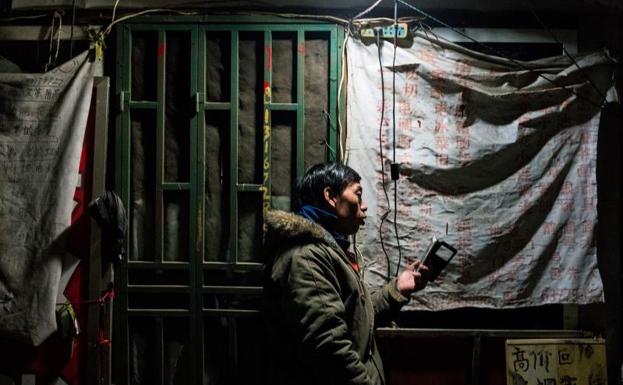 Un hombre mira su teléfono en Shanghái./Afp