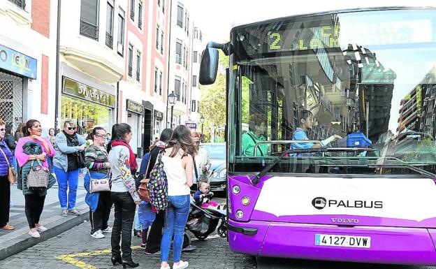 Varios vecinos suben al autobús urbano en la plaza de León. /Marta Moras