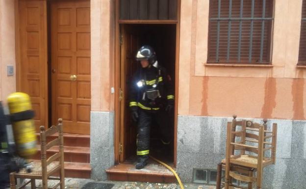 Un bombero sale de la casa afectada por el incendio de este lunes por la mañana en el barrio de San Lorenzo. /C. B. E.