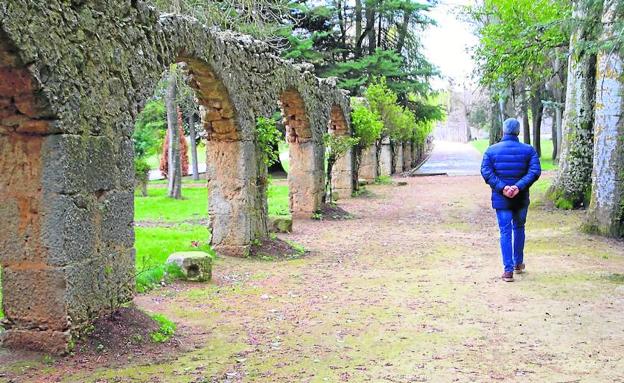 Los arcos del acueducto que llevaban el agua a la colegiata de la localidad, al fondo, rodeados de arboleda./M. G. M.