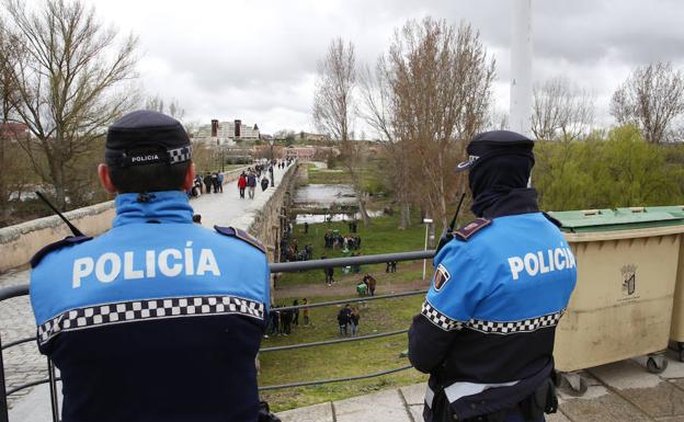 Dos agentes de la Policía Local vigilan al escaso grupo de personas que celebraban ayer el Lunes de Aguas a mediodía. /LAYA