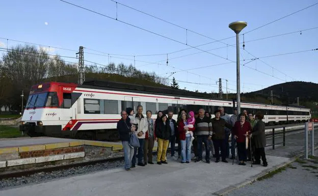 Vecinos del núcleo de La Estación del Espinar posan frente a un tren. /Pedro L. Merino