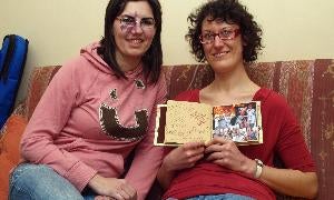 La presidenta de La Tahona, Maru González, y Marta Marchesi, que muestra un álbum de fotografías. / C. Catalina/
