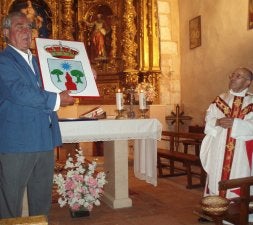 El alcalde muestra y explica el escudo, ante el párroco. / EL NORTE/