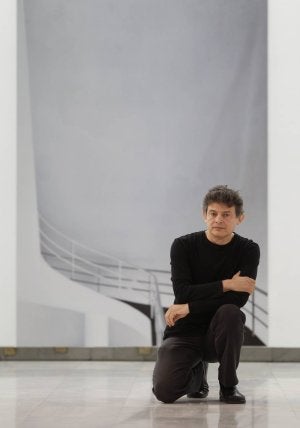 José Manuel Ballester posa delante de una de sus obras. En la fotografía inferior, una mujer estudia una de las cincuenta nuevas obras del artista madrileño. :: JOSÉ RAMÓN LADRA/