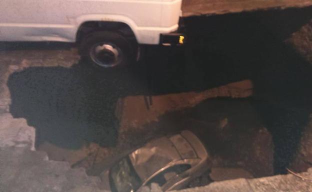 Un enorme socavón provocado por la tormenta engulle un coche y una furgoneta y obliga a desalojar un edificio en Segovia