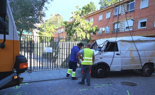 Una grúa extrae, destrozados, los vehículos que cayeron al socavón de diez metros de profundidad