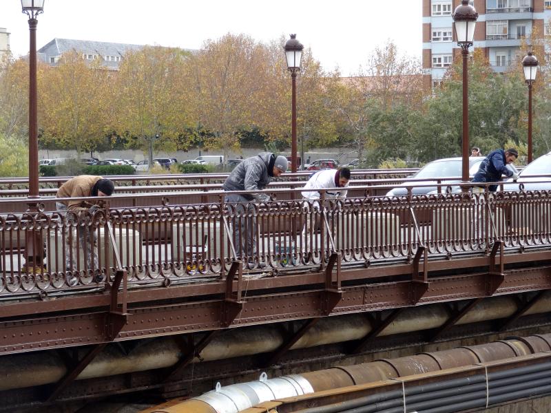 La última mano de pintura a la barandilla anticipa la reapertura de la acera del Puente Mayor de Valladolid
