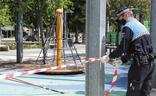 Un policía local recoloca la cinta del precinto de la zona de juegos del Salón./Marta Moras