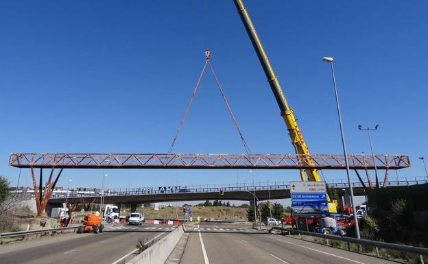Una grúa retira la vieja pasarela oxidada de la carretera de Segovia en Valladolid