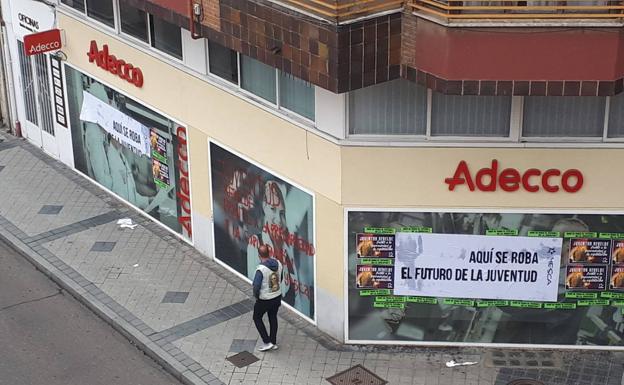 Cuatro jóvenes cubren de carteles y pintadas la fachada de la ETT Adecco en Valladolid