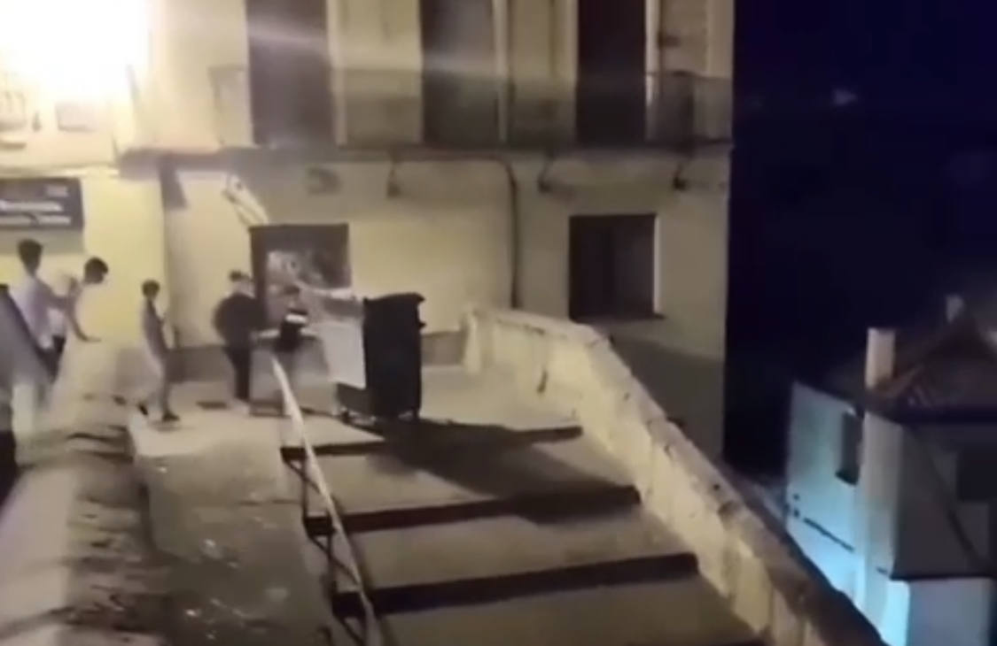 Un grupo de jóvenes arroja un contenedor escaleras abajo por La Canaleja, en Segovia