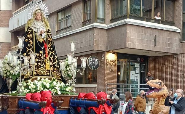 Las imágenes de un hombre disfrazado de dinosaurio viendo una procesión se vuelven virales