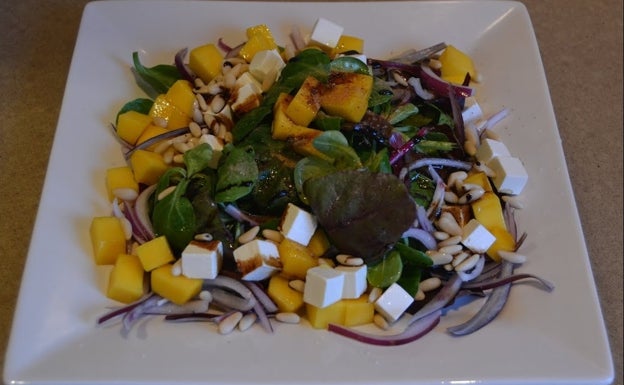 Ensalada templada de mango y piñones con un toque de queso