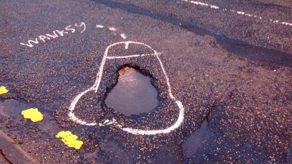 Un artista pinta penes en los baches