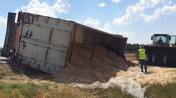 Aparatoso vuelco de un camión cargado con virutas de madera en la autovía de Pinares